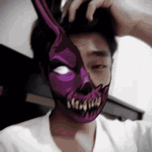 a man wearing a purple mask with a skull on his face .