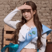 the girl is wearing a white shirt and a blue sash around her waist .
