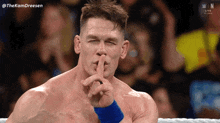 a wrestler is making a shhh gesture with his finger on his lips