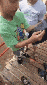 a young boy wearing a green shirt that says just do it