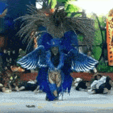 a person in a blue costume with wings is dancing