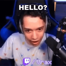 a young man wearing headphones is sitting in front of a microphone and says hello ?
