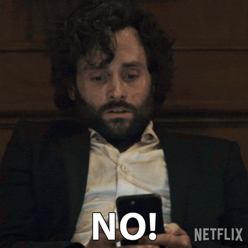 a man with a beard is holding a cell phone and saying 