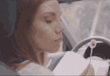 a woman is reading a book while holding a lollipop in her hand
