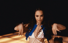 a woman with long curly hair is dancing in a blue and white bikini top .