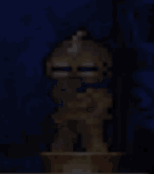 a pixelated image of a statue of a man sitting on a table with a book .