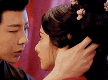 a man is touching the head of a woman in a traditional costume .