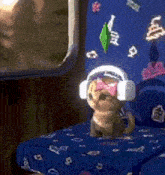 a small dog wearing headphones and sunglasses is sitting on a bed .