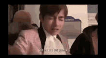 a man in a suit and tie is crying while sitting on a plane .