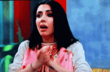 a woman in a pink shirt is making a face