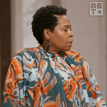 a woman with her eyes closed is wearing a floral dress