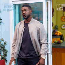 a man standing in front of a door that says tyler perry 's house of payne