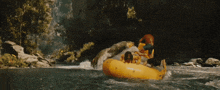 a person is riding a yellow raft in a waterfall
