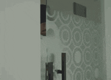 a man is peeking out from behind a glass door in a room .