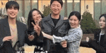 a group of people are posing for a picture with a man in a leather jacket