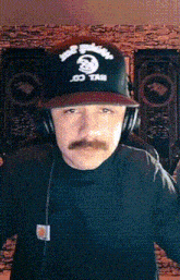 a man with a mustache wears a hat that says evil co. taxi