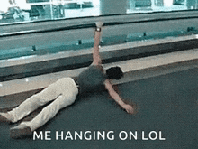 a man is laying on the floor with his arm up .
