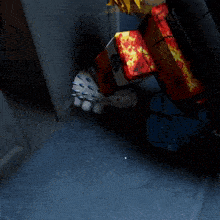 a cartoon character is sitting in a dark room with a few boxes on the floor