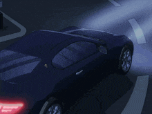 a dark blue car is parked in a parking lot at night