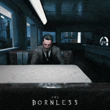 a man sits at a table with the words the bornless on the bottom right
