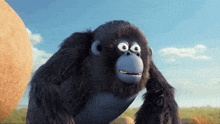 a cartoon gorilla with a blue face is standing next to a large rock