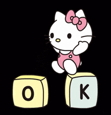 hello kitty standing on a block with the letter o on it