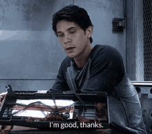 a man is sitting in front of a box that says ' i 'm good thanks '