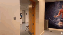 a hallway with a picture of a soccer player on the wall and a chair .