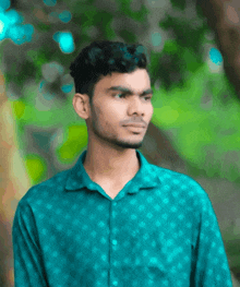 a young man in a blue shirt looks to his left