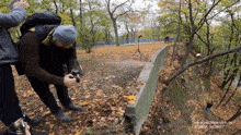 a man taking a picture in the woods with the website www.peche-delo.by visible