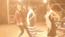 a group of people are standing on a stage and one of them is wearing a shirt that says ' a ' on it