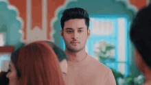a man in a pink shirt stands in front of a group of women