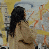 a woman is standing in front of a wall with posters on it including one that says " tsn "