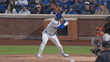 a baseball player getting ready to swing at a pitch while a fan wearing a brtn shirt watches