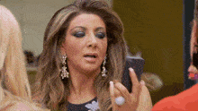 a woman is looking at herself in the mirror while holding a cell phone