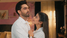 a man and a woman are standing next to each other in a room .