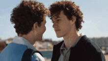 two men are looking at each other with their eyes closed