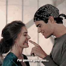 a man in a bandana is touching a woman 's nose and says " i 'm gonna give you ... "