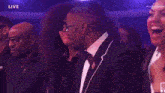a woman in a white dress is standing next to a man in a black suit