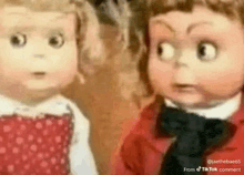 a boy and a girl doll are standing next to each other .