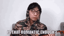 a man in a camo hoodie and glasses is playing a violin and asking is that romantic enough .