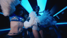 a woman with a tattoo on her stomach is dancing in a club
