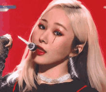a woman with blonde hair is singing into a microphone .