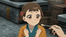 a little girl is being fed with a spoon by someone