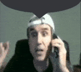 a man talking on a cell phone with a speech bubble above his head