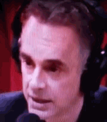 a close up of a man wearing headphones and a microphone