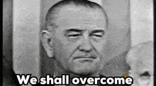 a black and white photo of a man with the words we shall overcome above him
