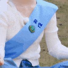 a person wearing a white shirt and a blue sash with chinese writing