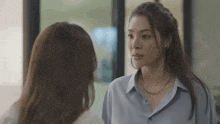 two women are looking at each other in a room .