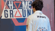 a man standing in front of a sign that says #home ground